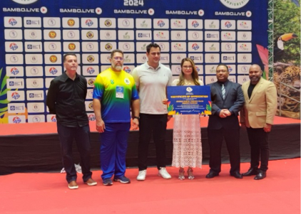 Dirigentes e a primeira-dama de Mato Grosso, Virginia Mendes, com o certificado de madrinha do SAMBO no palco do Pan-Americano 2024
