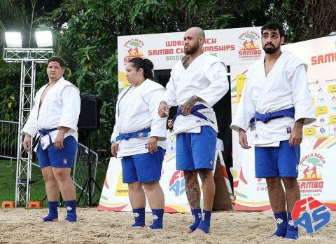 Atletas da seleção brasileira de quimono branco e faixa azul na arena de areia do World Beach Sambo, em Singapura