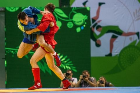 Luta de SAMBO esportivo: atleta de azul projeta o adversário de vermelho