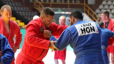 Adalberto Corrêa Jr., de quimono vermelho, em pegada com adversário de quimono azul durante luta de SAMBO